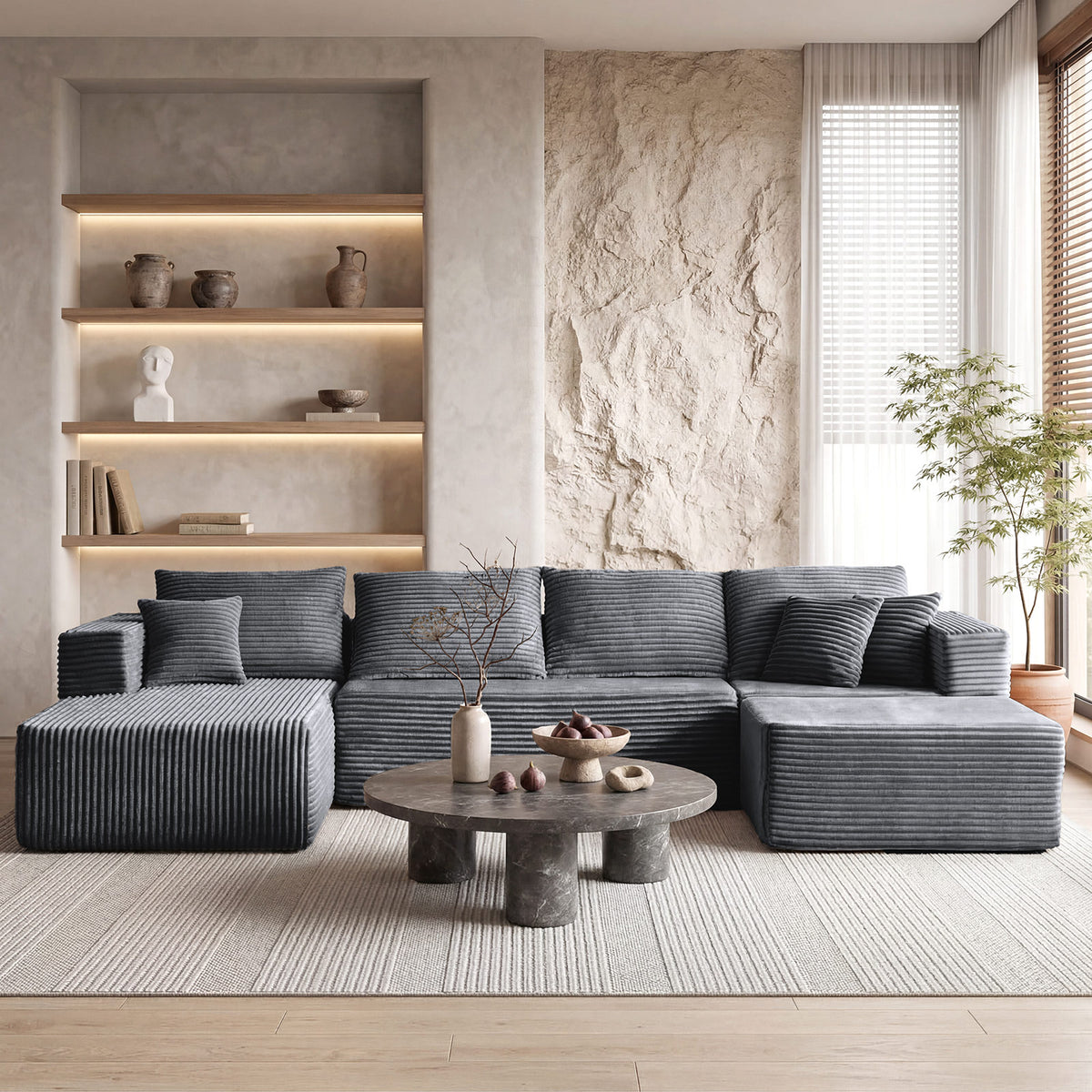 [Gray] corduroy U-shaped sectional sofa — full front view in modern minimalist living room with stone round coffee table and built-in illuminated shelving, showing 4-seat plus dual chaise layout