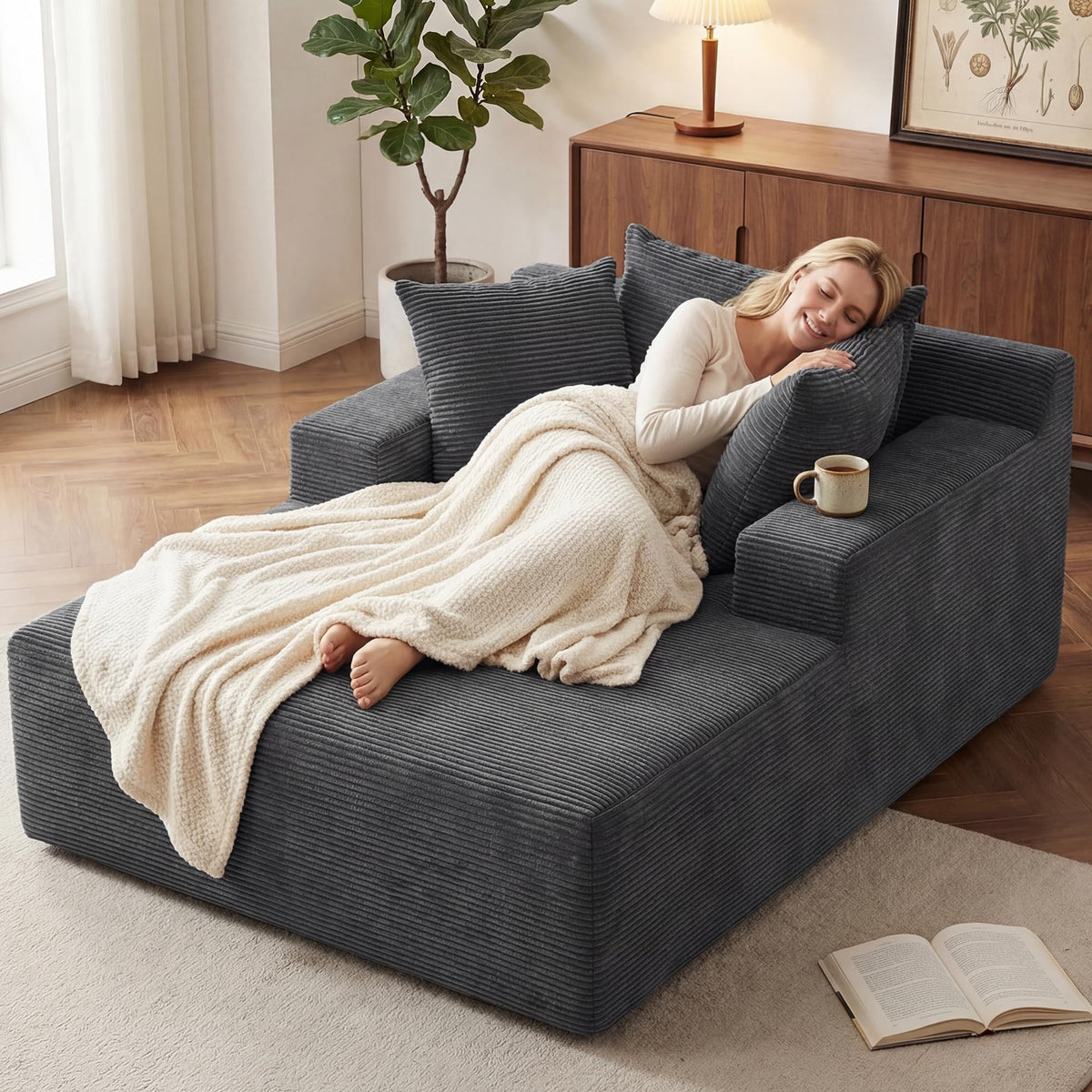 [Gray] oversized corduroy chaise lounge chair — woman napping with throw blanket, mug on armrest, and open book on floor, showing cozy relaxation use case